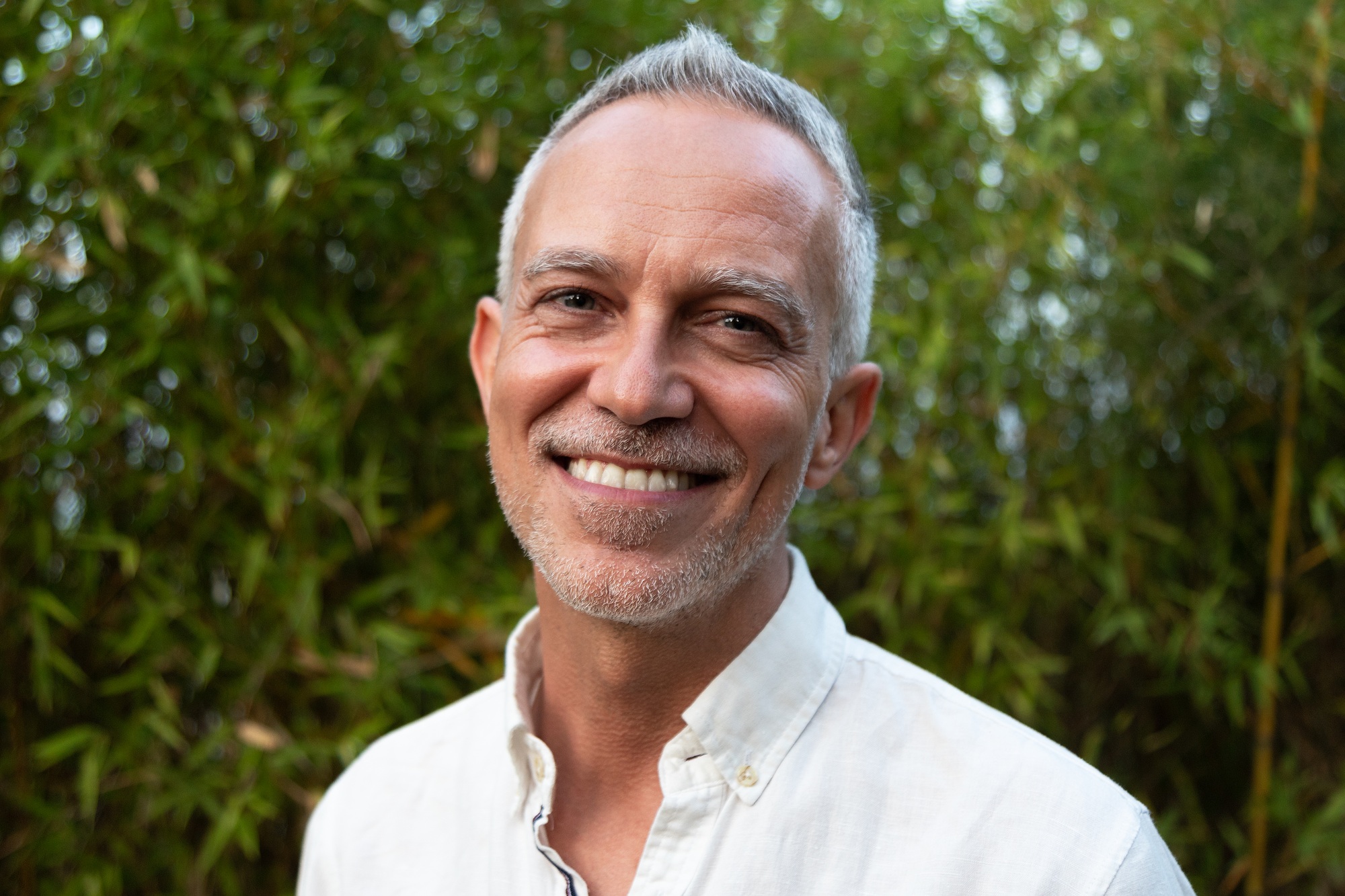 Horizontal headshot of smiling white man in nature.